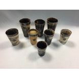 A collection of eight horn beakers with silver mounts, six bearing various spread eagle crests on