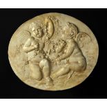 A pair of 19th century oval plaster reliefs of cherubs, one depicting amorini with a chain of