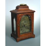 A George III mahogany bracket clock, the bell top case with carrying handle above brass dial