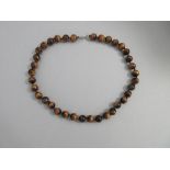 A tiger's eye bead necklace, the uniform 10mm spherical beads of golden brown tiger's eye