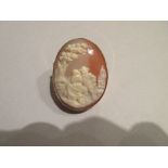 A simulated shell cameo brooch depicting bucolic lovers, the young couple in 17th century dress,