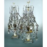 A pair of three light lustre candelabra, the glass beads hung from gilt wires about the central