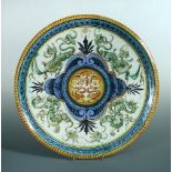 A 19th century Majolica charger, decorated in Renaissance style with fanciful beasts, within blue