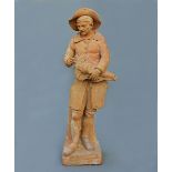 An 18th century French terracotta figure, the standing subject playing the Hurdy-Gurdy, signed F