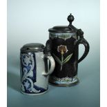 A German faience and pewter mounted lidded tankard, the body decorated with a shaped cartouche