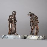 After Giambologna, a pair of 17th century bronze figures of pedlars, on oval Bardiglio marble