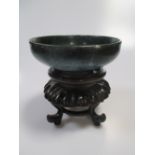 A Chinese high fired blue bowl, possibly Song dynasty, and wood stand