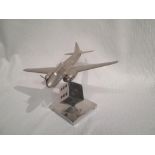 A nickel plated model of a WWII bomber, the stand in the form of a dice, on square base, wingspan