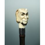 A late 19th century ivory articulated cane handle, in the form of Pan's head, the silver collar