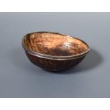 A mid 19th century coconut bowl, Banca 1857, with white metal collar, the body with simple