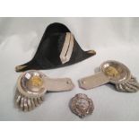 A pair of Victorian white metal epaulettes, together with a bicorn hat, both contained in tins, a