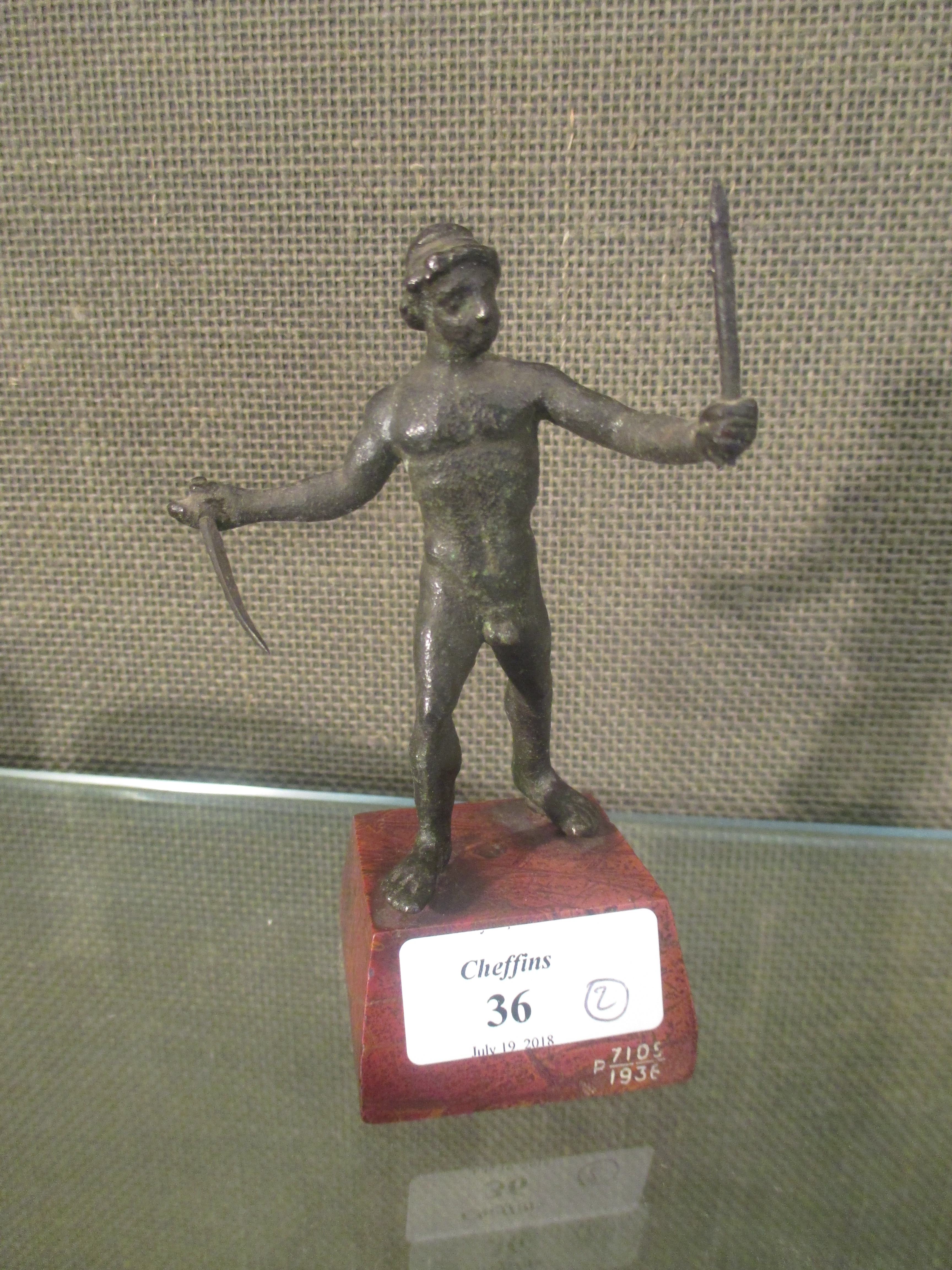A small bronze after the Antique of a standing man holding swords