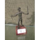 A small bronze after the Antique of a standing man holding swords