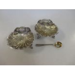 A pair of Victorian silver shell salts, Birmingham 1890, with gilded bowls, each raised on three