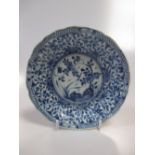 A Kangxi blue and white small dish, the central flowers and rock enclosed by a dense band of