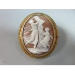 A 19th century shell cameo brooch depicting flirtatious girls dancing around a statue, collet set in