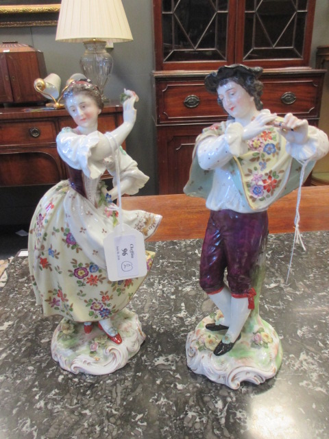 A pair of late 19th century Continental porcelain figures of a man and wife, 24cm high