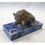 A Russian bronze bear mounted on a lapis lazuli base, the seated figure once gilt, it shows its