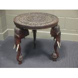 An Anglo Indian carved occasional table on elephant head supports, 62cm high