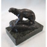 A bronze model of a Polar bear walking up a rocky ledge, the rectangular plinth of serpentinite,