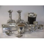 A collection of silver to include a pair of loaded dwarf candlesticks, a pair of napkin rings, six