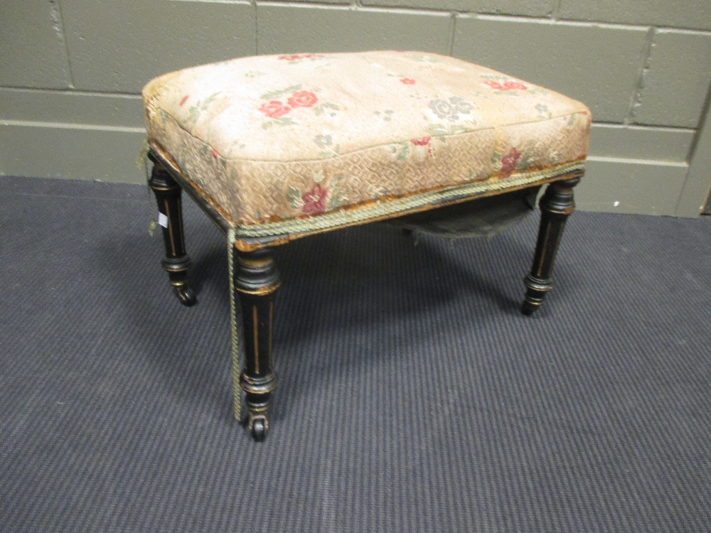 A Victorian stool with upholstered seat and gilt fluted legs and caster feet