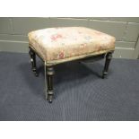 A Victorian stool with upholstered seat and gilt fluted legs and caster feet