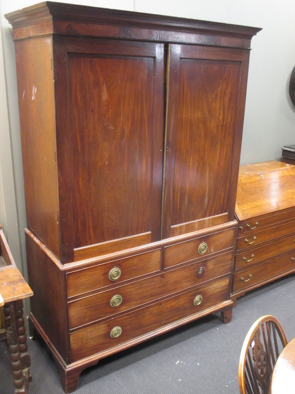 A George III mahogany linen press with slides, on swept bracket feet, 203 x 132 x 61cm