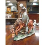 A Capodimonte figure of Don Quixote; two plates painted by J. Selwyn Dunn and another plate (4)