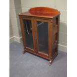 An Edwardian mahogany bookcase and a mahogany framed wall mirror with sconces (2)