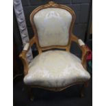 A pair of Louis XVI style giltwood chairs, upholstered in gold material