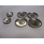 Four Chinese silver dishes inset with 'Kuang Hsu' coins and two other small bowls