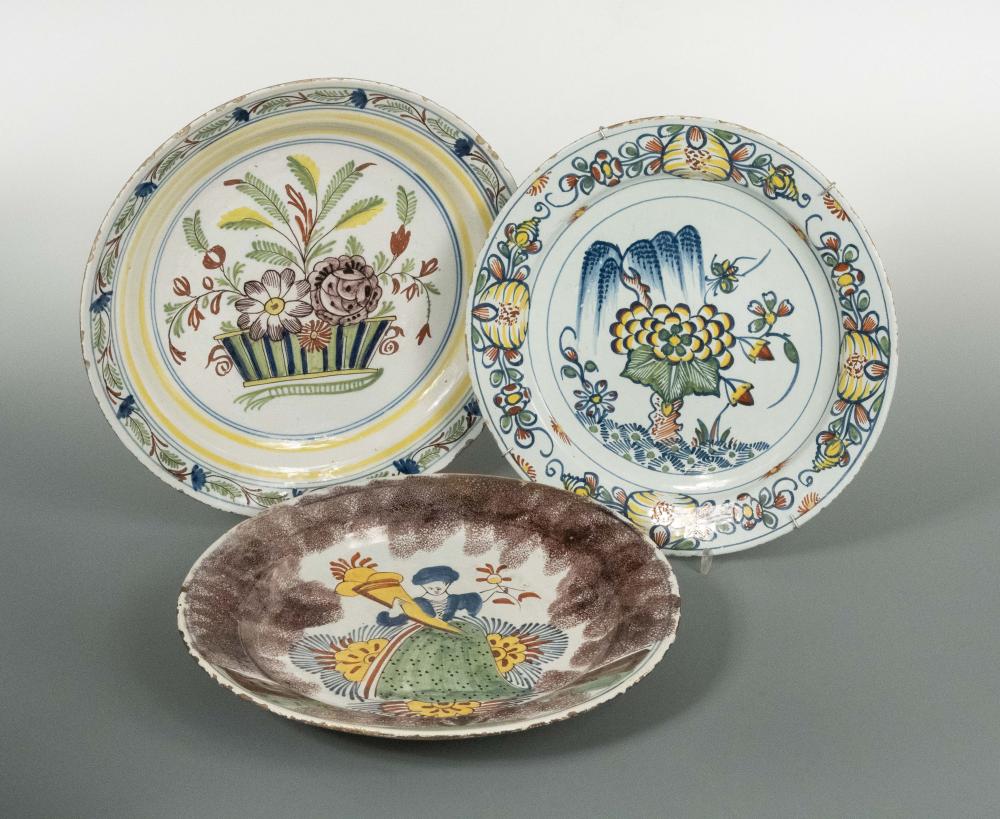 An 18th century Delft plate, decorated to the centre with a lady holding a cornucopia, within a
