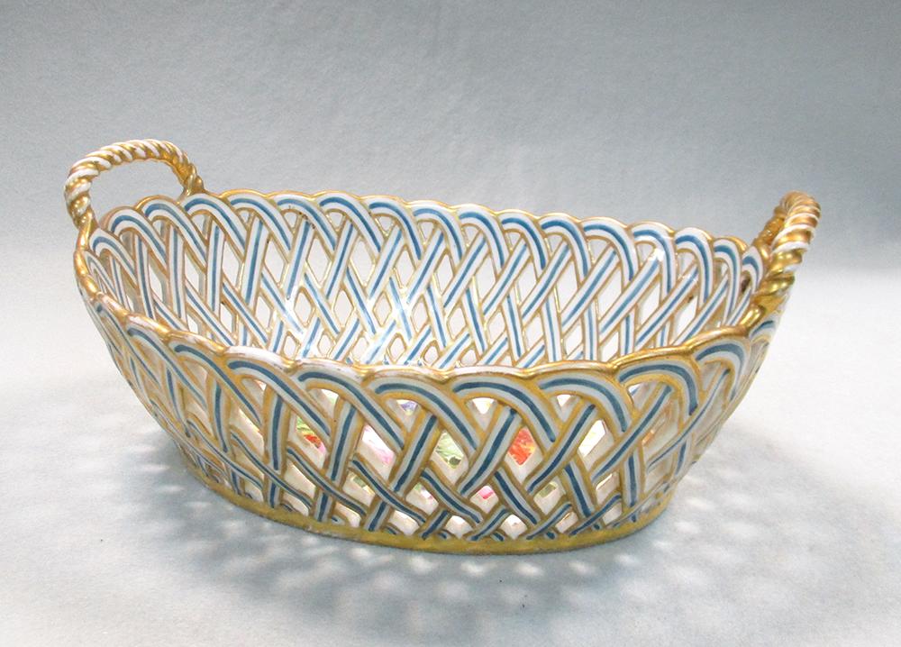 A 19th century English porcelain two handled pierced basket, the centre painted with a bouquet of