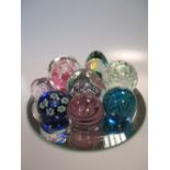 Eight Mdina and other glass paperweights on a mirror (9)