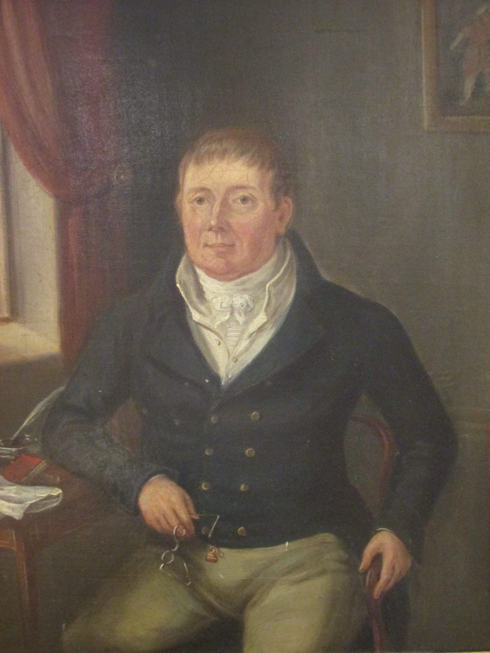 English School, circa 1810, a gentleman seated by a window holding his spectacles with his left