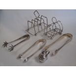 Two silver toastracks, two pairs of silver sugar tongs, a pair of silver ice tongs and a miniature