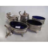 A group of three silver open salts with blue glass liners and spoons, and two silver mustard pots,