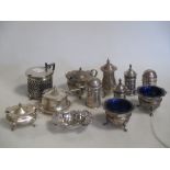 A collection of silver condiments including a pair of pierced pepper casters with glass liners,