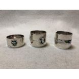 Liberty & Co., two silver and enamel napkin rings and another by William H. Haseler, variously