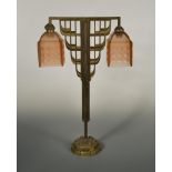 An Odeonesque brass table lamp, with twin frosted pink glass shades 55 x 36cm (21 x 14in)