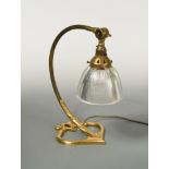 In the manner of W.A.S. Benson, a brass table lamp, the curving arm supporting the original glass