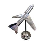 A large contemporary polished aluminium model of an aeroplane, mounted to a column and raised on a