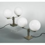 A pair of French twin-branch table lamps, the silvered brass lamps on stepped square bases with