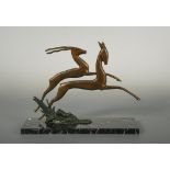 An Art Deco bronze model of two gazelles, the stylised painted and patinated bronze animals