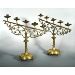 A pair of Gothic brass altar candlesticks, each with angled line of five sconces above scroll work