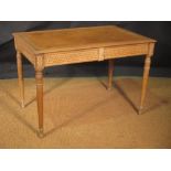 A Continental carved beech wood library table with guilloche carved blind freize drawers on turned