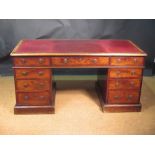 A 19th century mahogany pedestal desk, the red leather lined top above an arrangement of nine