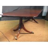 A George III style mahogany twin pedestal dining table with additional leaves, on three support