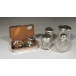 A set of four silver ashtrays, a small silver capstan inkwell and a collection of silver topped